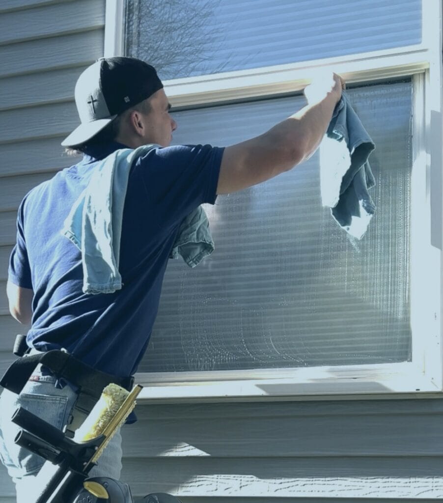 Alta Cleaning technician cleaning an exterior window at a Utah home