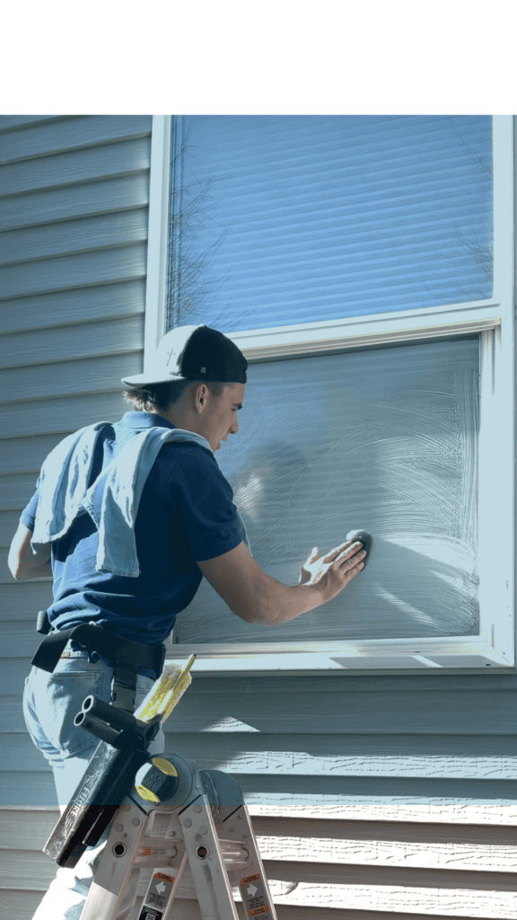 Alta Cleaning technician rinsing an exterior window pane